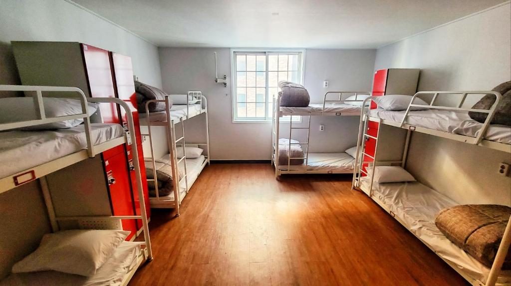 Dorm bunks and lockers along a guesthouse hallway