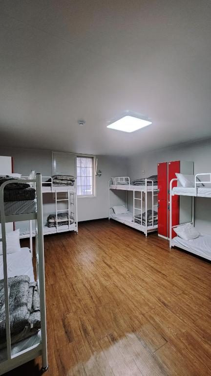 A dorm room with bunk beds and personal lockers, representing bed-level inventory in a guesthouse.