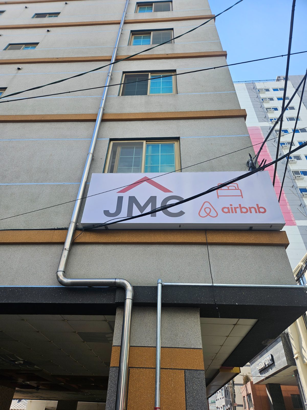 The guesthouse building exterior with an Airbnb sign, one of the OTA listings that must map correctly to real rooms