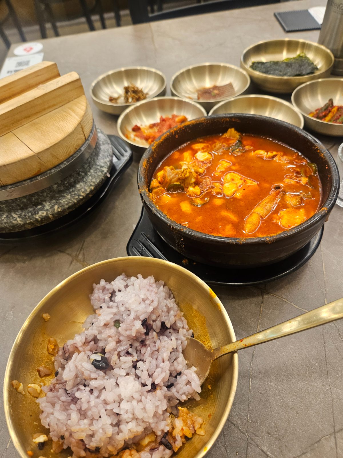 A spicy Korean soup with rice and side dishes