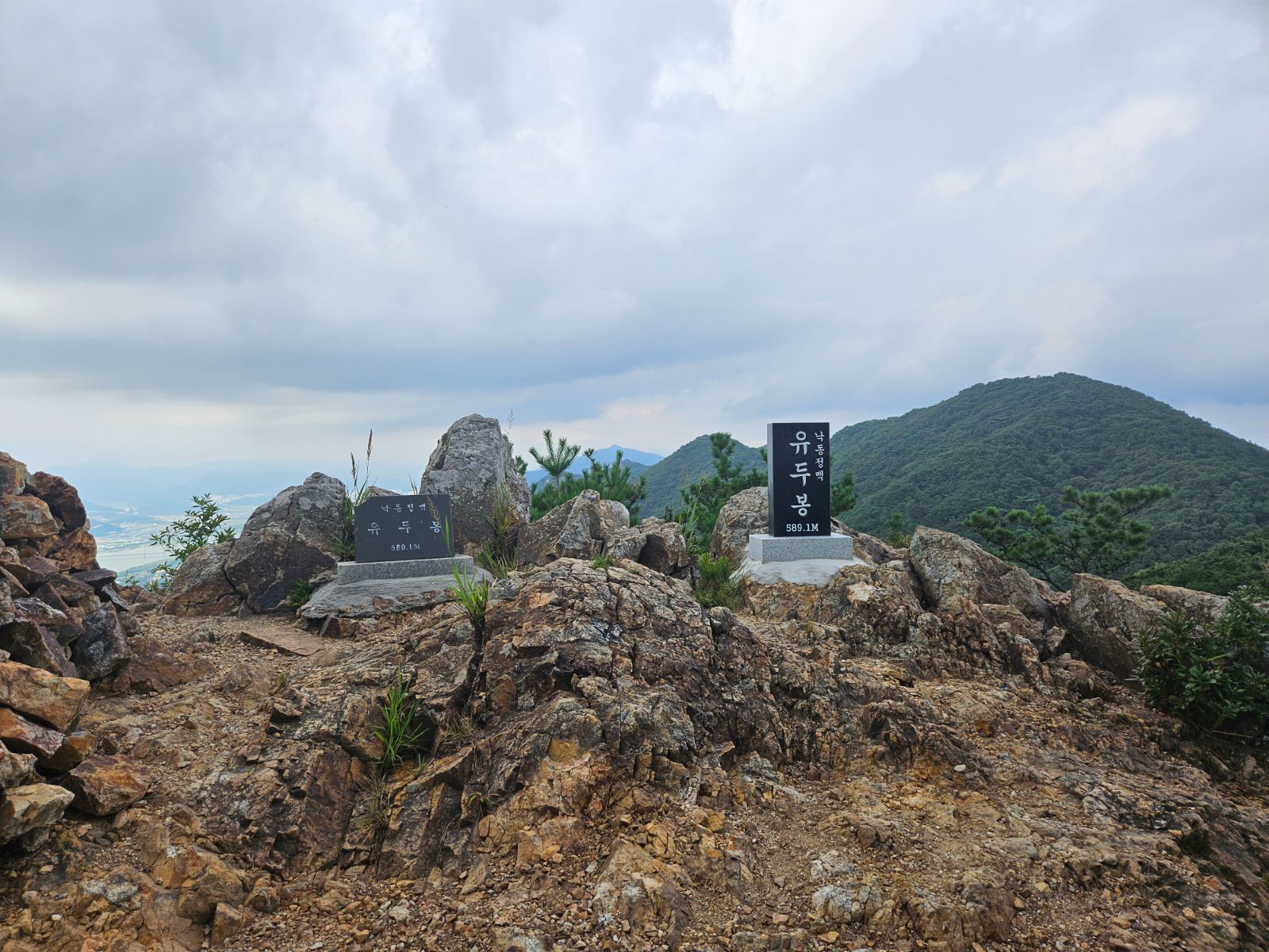 秋の慶州のハイキングコース山頂にある標石と遠くの谷の眺め