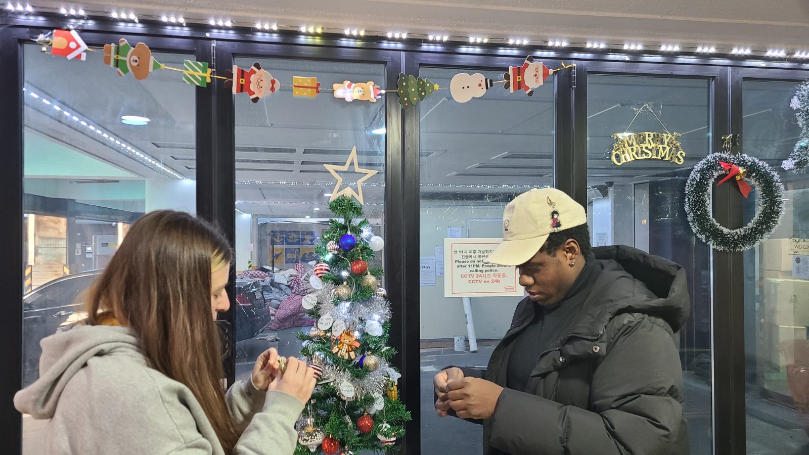 Guests meeting in a guesthouse hallway decorated for Christmas
